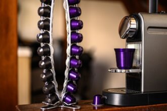 Eine weiße Nespresso-Maschine mit Milchbehälter, die eine Tasse Kaffee mit feinem Milchschaum zubereitet – ideal für bewussten Genuss.