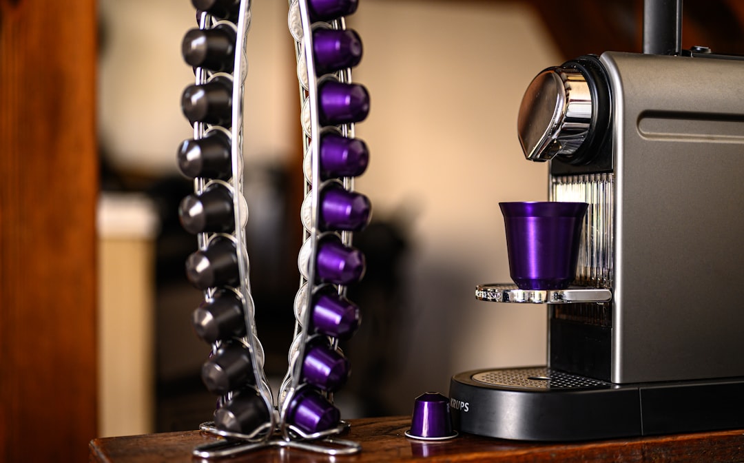 Eine weiße Nespresso-Maschine mit Milchbehälter, die eine Tasse Kaffee mit feinem Milchschaum zubereitet – ideal für bewussten Genuss.